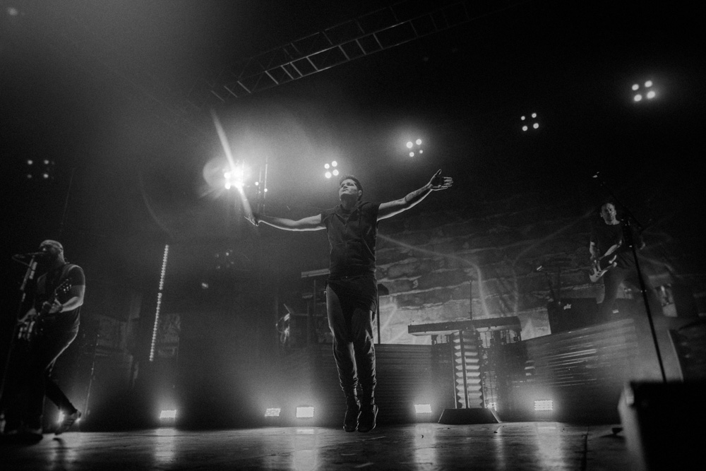 Danny O'Donoghue from The Script jumping, arms outstretched on stage on the 2017 Uk Tour