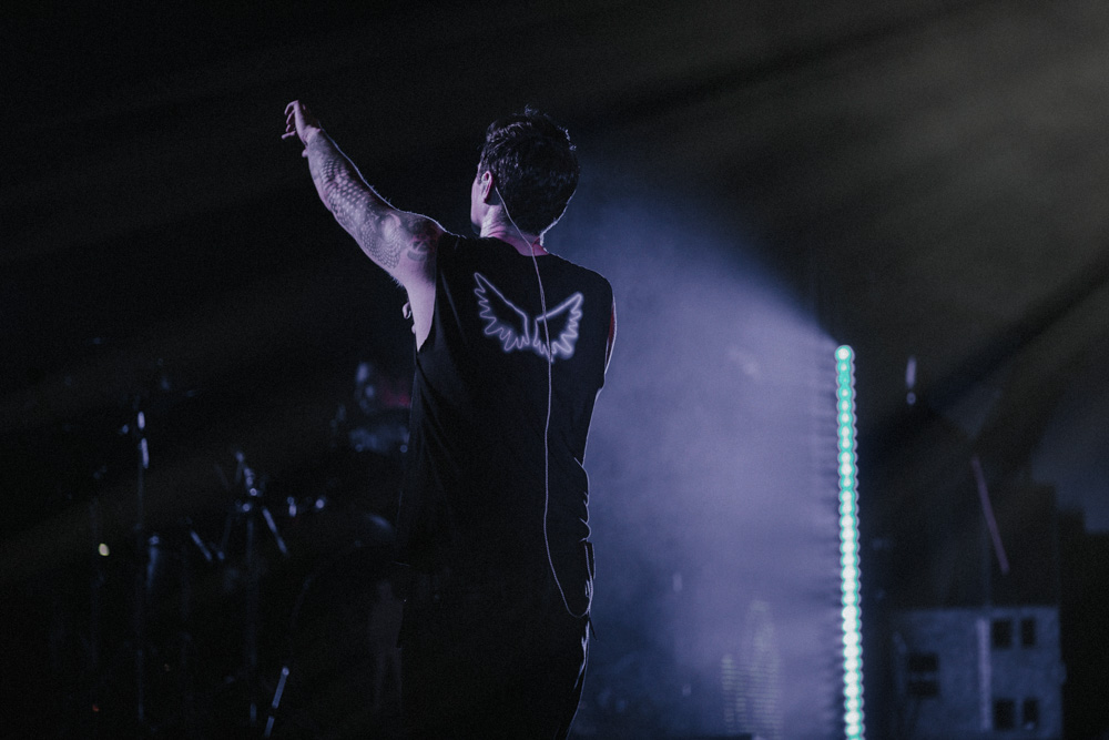 Danny from The Script on 2017 UK Tour wearing vest top raising arm to crowd