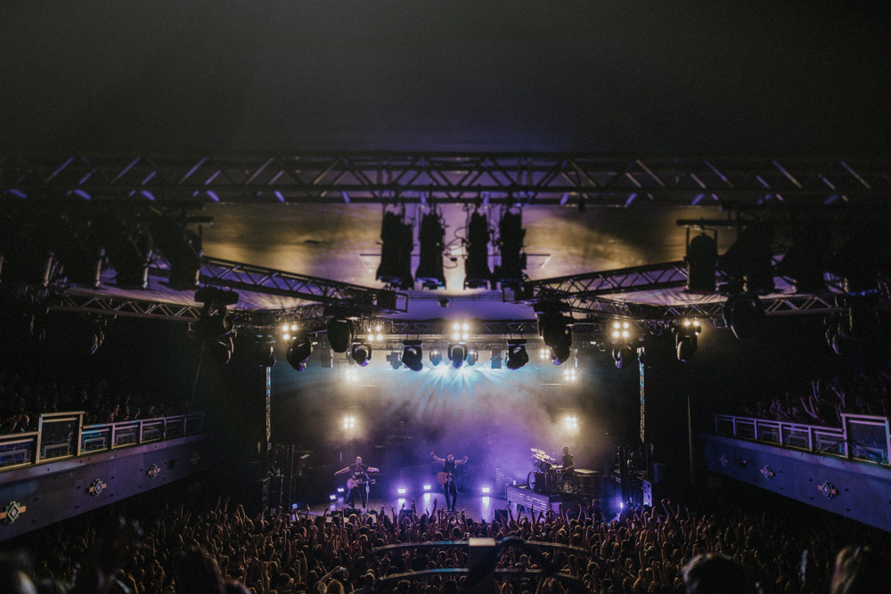 Photograph of The Script on stage performing during their 2017 tour from balcony